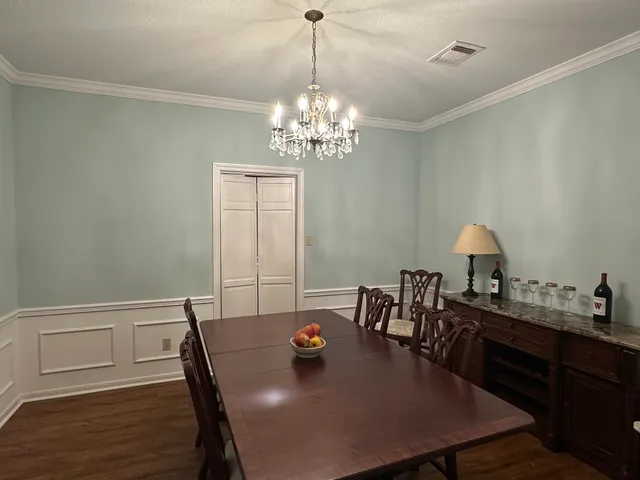 a view of a dining room with furniture and chandelier