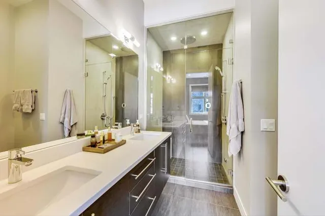 a bathroom with a double vanity sink mirror and shower