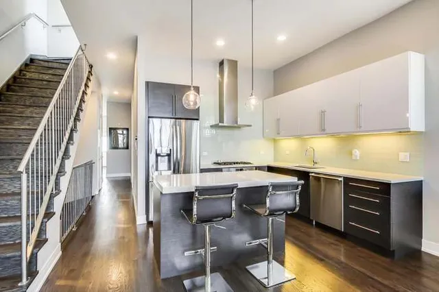 a kitchen with a sink cabinets and wooden floor