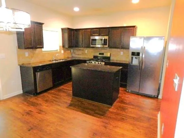 a kitchen with stainless steel appliances granite countertop a stove a sink dishwasher a refrigerator and a microwave oven