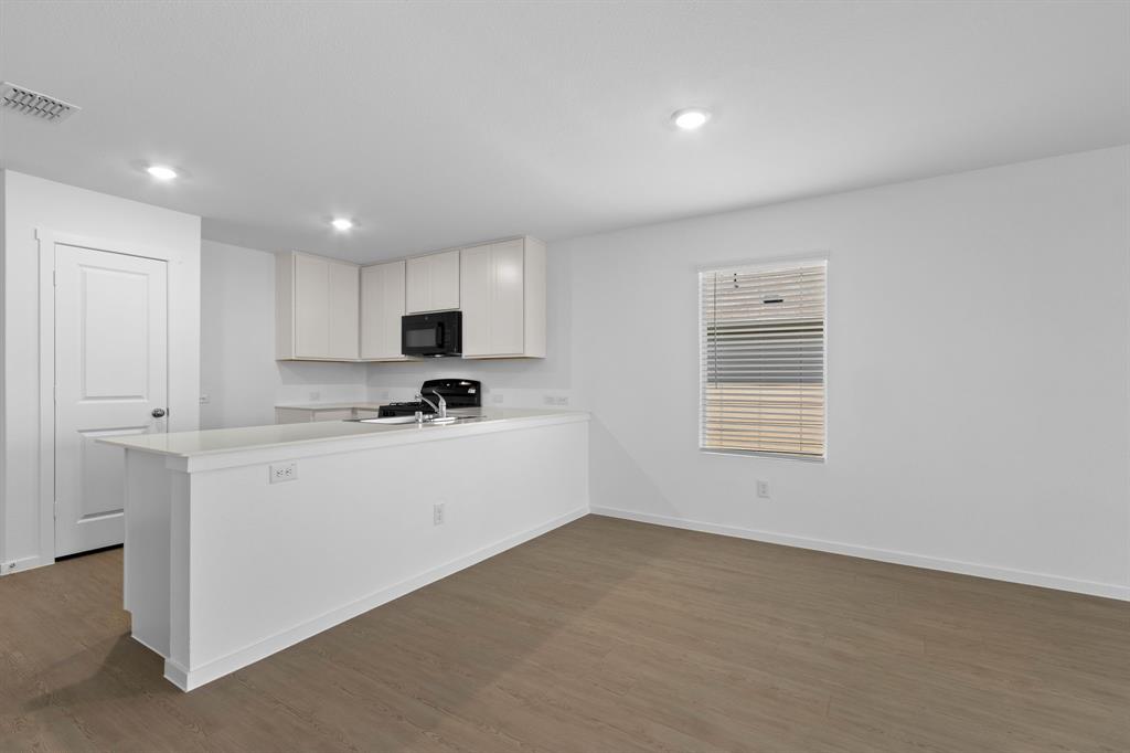 11333 Rodeo Drive Providence Village, TX 76227 - Photo 11 of 39 a kitchen with granite countertop white cabinets and white appliances