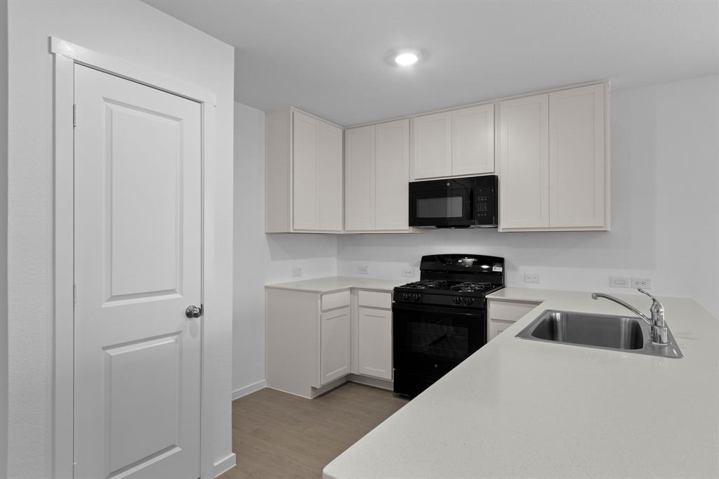 11333 Rodeo Drive Providence Village, TX 76227 - Photo 12 of 39 a kitchen with a sink and a stove top oven