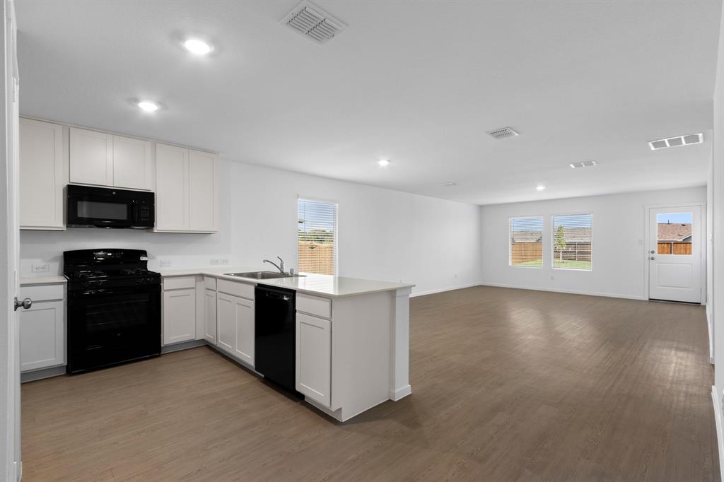 11333 Rodeo Drive Providence Village, TX 76227 - Photo 6 of 39 a kitchen with stainless steel appliances granite countertop a stove and a refrigerator