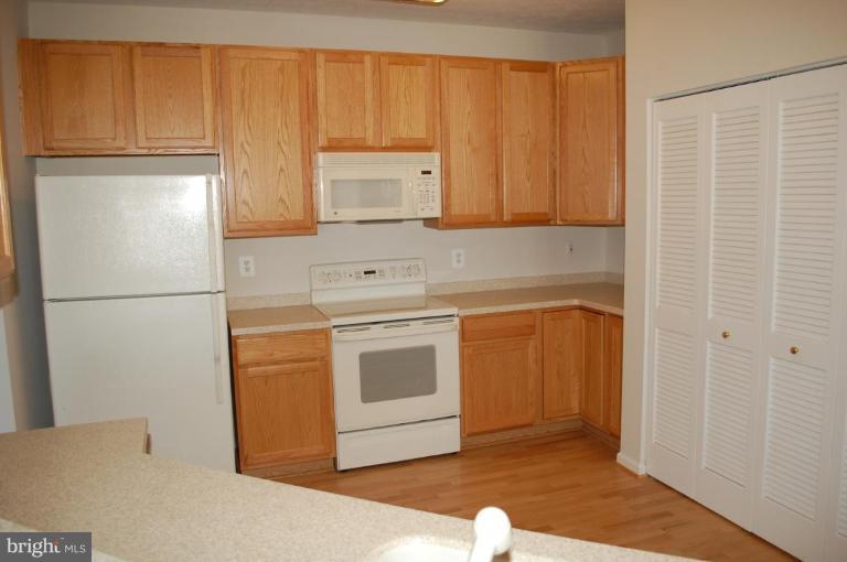 5238 Glenthorne Court, Unit 5238 Rosedale, MD 21237 - Photo 4 of 14 a kitchen with a refrigerator sink and cabinets