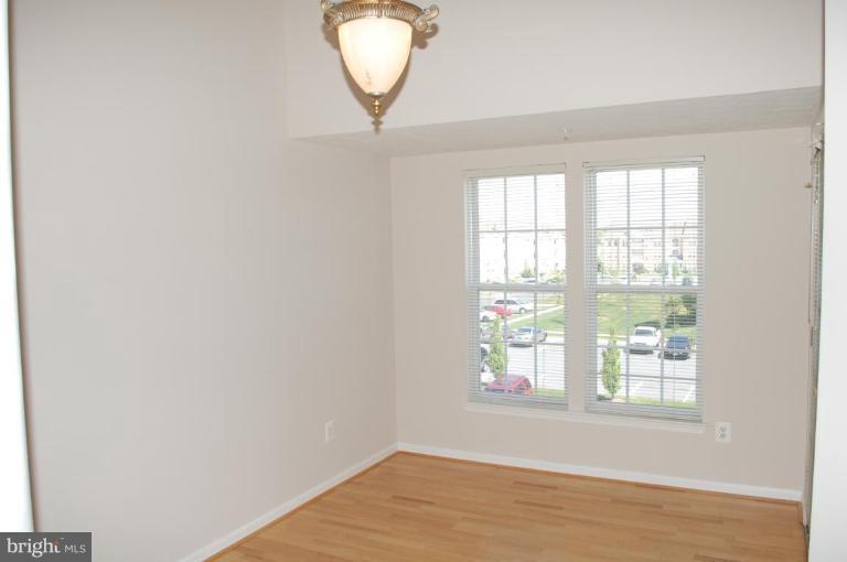 5238 Glenthorne Court, Unit 5238 Rosedale, MD 21237 - Photo 6 of 14 an empty room with wooden floor and windows