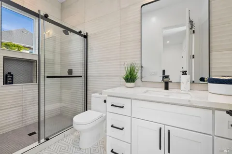 a bathroom with a granite countertop sink toilet and shower