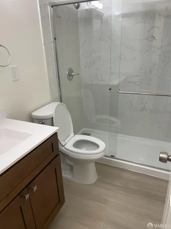 a white toilet sitting next to a bathroom sink and a shower