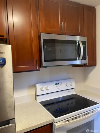 a kitchen with wooden cabinets and a stove top oven