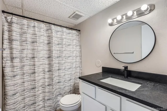 a bathroom with a granite countertop sink and a mirror