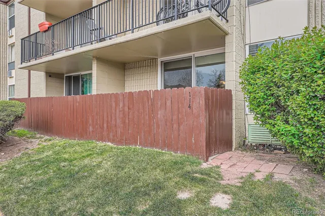 a view of backyard with potted plants and wooden fence