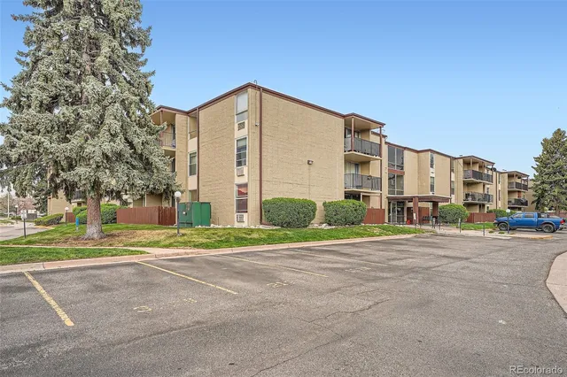 a view of a tall building next to a yard