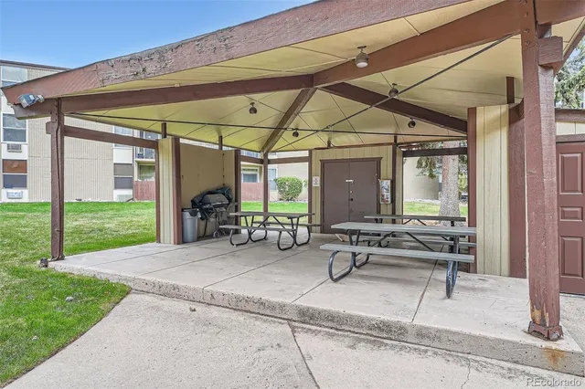 a view of a patio with table and chairs under an umbrella