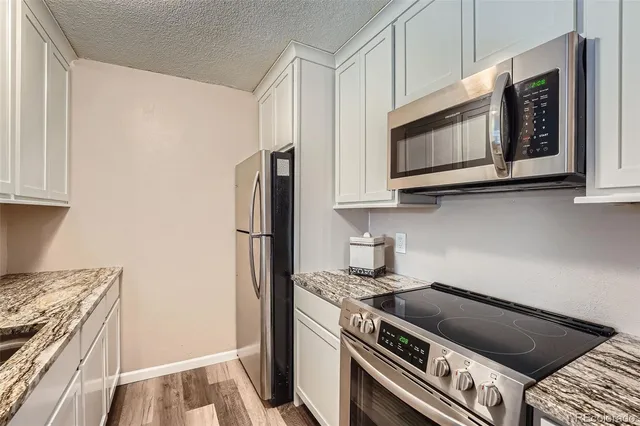 a kitchen with stainless steel appliances granite countertop a stove and a microwave