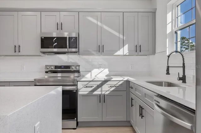 a kitchen with stainless steel appliances a refrigerator and a stove top oven