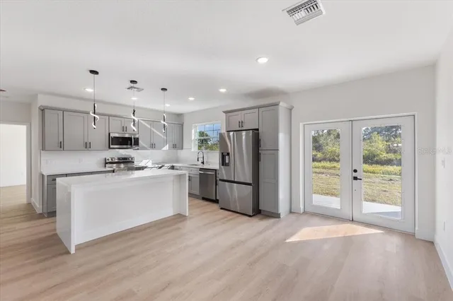 a large kitchen with a lot of cabinets and wooden floor