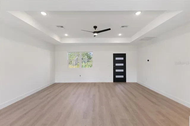 an empty room with a ceiling fan and wooden floor