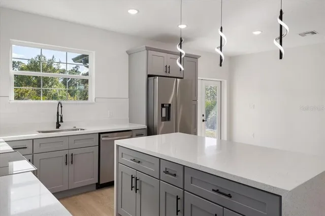 a kitchen with white cabinets and window