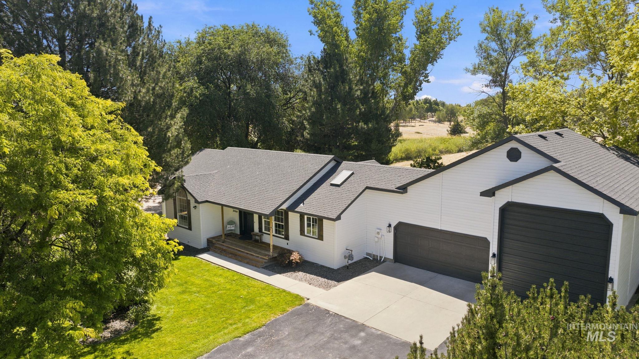 24864 Coventry Drive Caldwell, ID 83607 - Photo 2 of 49 White exterior with dark trim and a prominent three-car garage