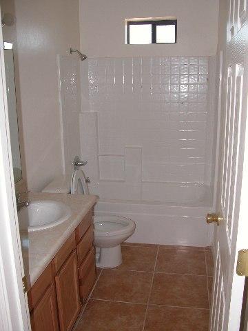 1793 Fritz Court Rio Rico, AZ 85648 - Photo 3 of 8 a bathroom with a granite countertop sink a toilet and shower
