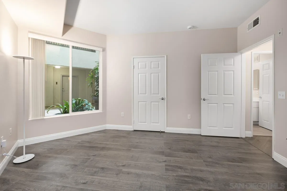 9229 Regents Road, Unit L124 La Jolla, CA 92037 - Photo 24 of 46 an empty room with wooden floor and windows