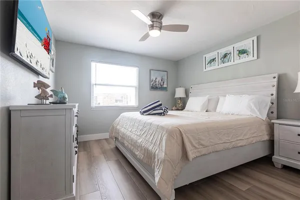 a bedroom with a large bed chandelier and a window