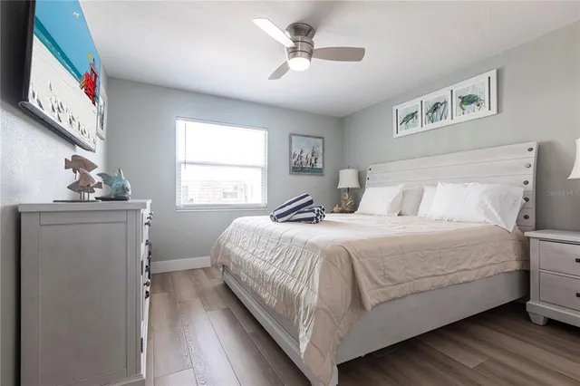 a bedroom with a large bed chandelier and a window