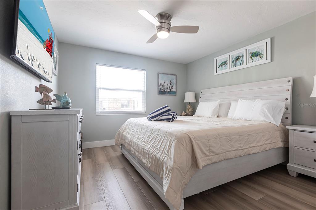 6020 Midnight Pass Road, Unit 35 Sarasota, FL 34242 - Photo 11 of 13 a bedroom with a large bed chandelier and a window
