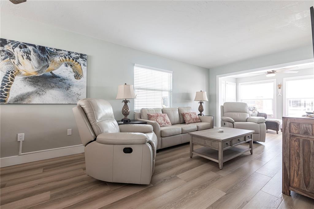 6020 Midnight Pass Road, Unit 35 Sarasota, FL 34242 - Photo 3 of 13 a living room with furniture and wooden floor