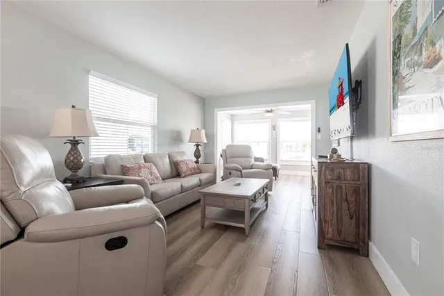 a living room with furniture a wooden floor and a window