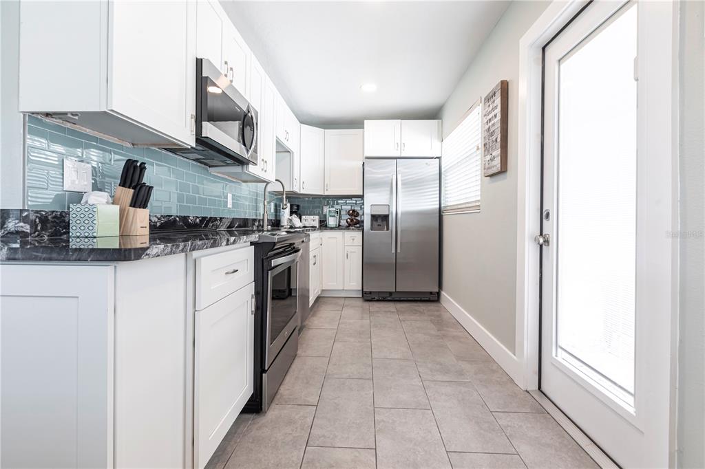 6020 Midnight Pass Road, Unit 35 Sarasota, FL 34242 - Photo 9 of 13 a kitchen with stainless steel appliances granite countertop a refrigerator and a sink