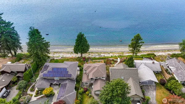 an aerial view of residential houses with outdoor space and trees