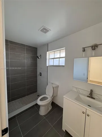 a bathroom with a toilet a sink a mirror and shower