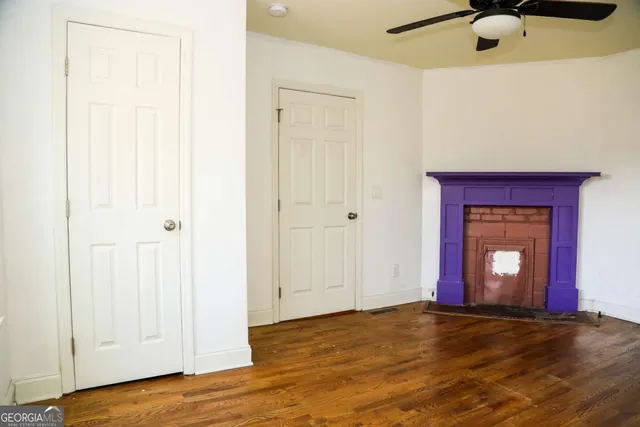 a view of an empty room with wooden floor and a cabinet