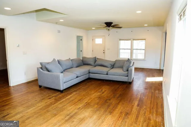 a living room with furniture and a wooden floor
