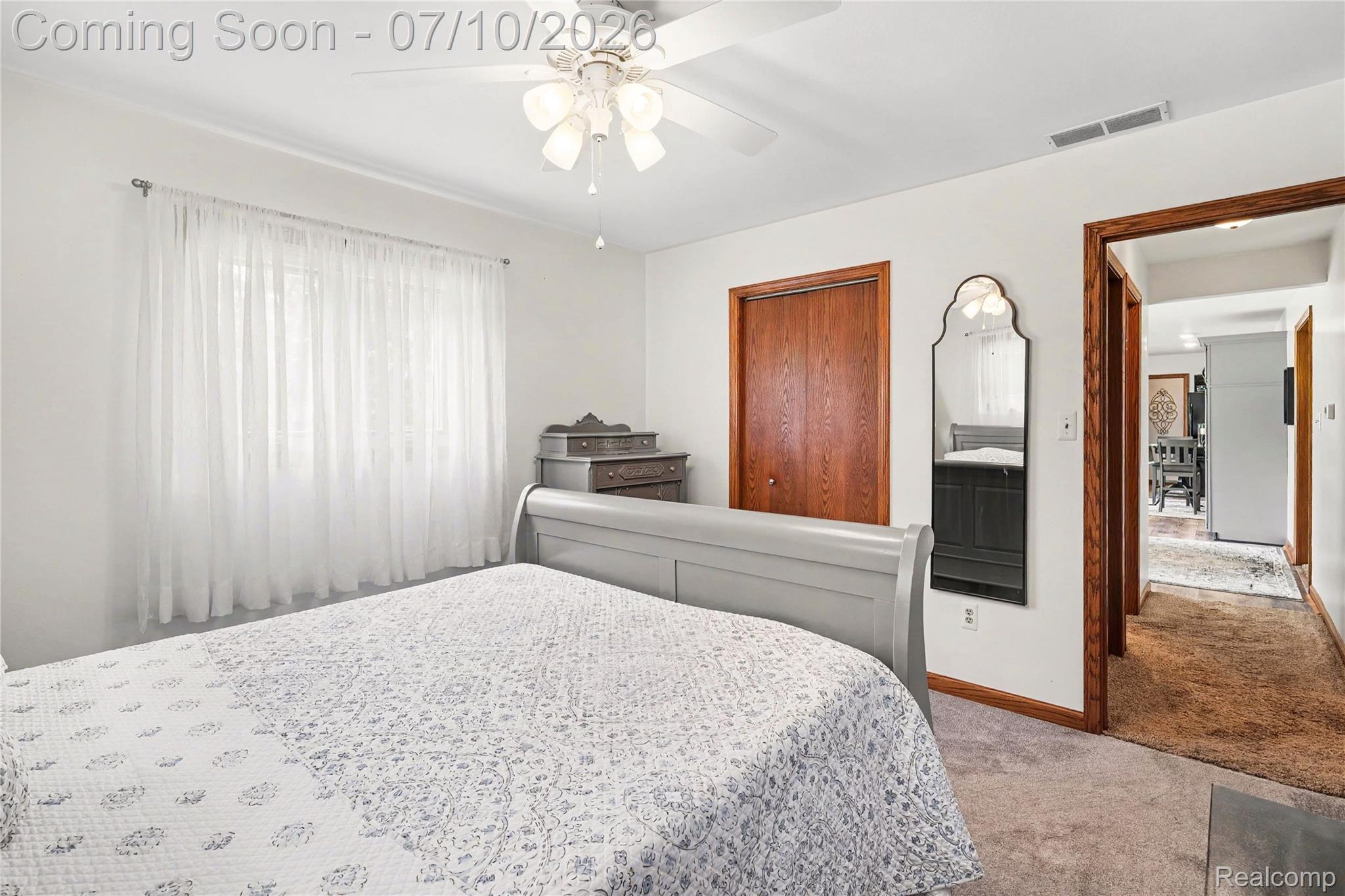 2180 Hurst Road St. Clair, MI 48079 - Photo 21 of 39 Bright room featuring a ceiling fan with light fixture, wood-finish closet doors, a large window with sheer curtains, and carpet flooring