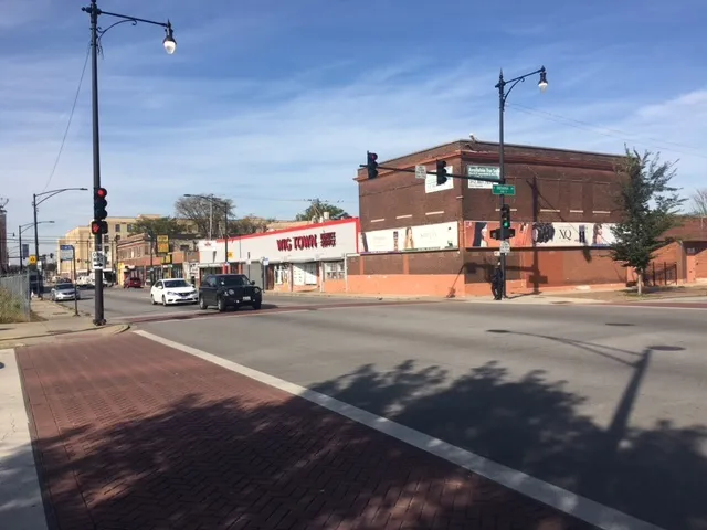 a city street with cars parked in front of it