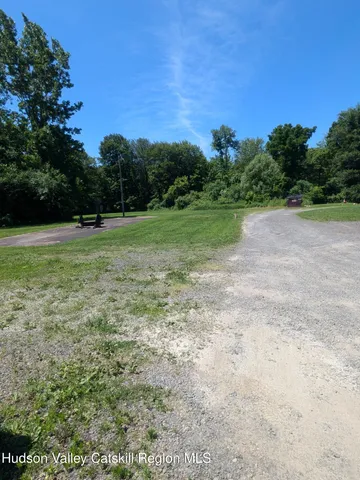 a view of a field with trees in the background