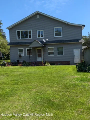 a front view of house with yard and trees