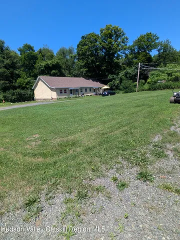 a view of a house with a yard and sitting area