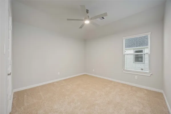 an empty room with an entryway and fan