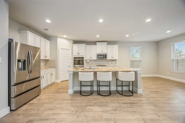 a kitchen with a sink and wooden floor