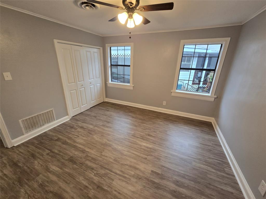 233 Roma Drive Shreveport, LA 71105 - Photo 11 of 12 Unfurnished bedroom with crown molding, dark wood-style floors, a closet, and ceiling fan
