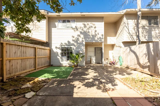 a view of a backyard with plants and large tree