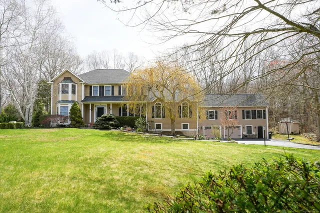 a view of a house with a big yard and large trees