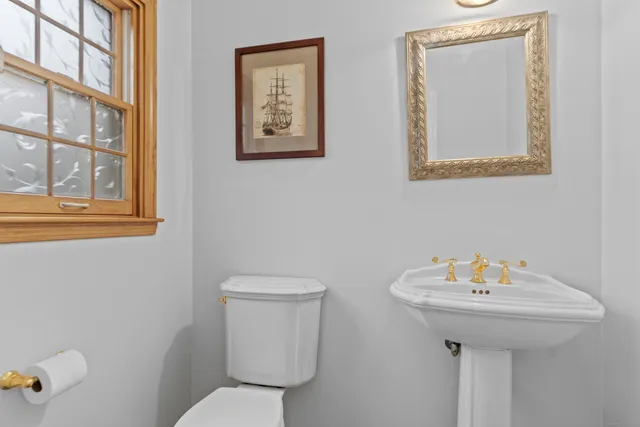 a bathroom with a toilet a sink and a mirror