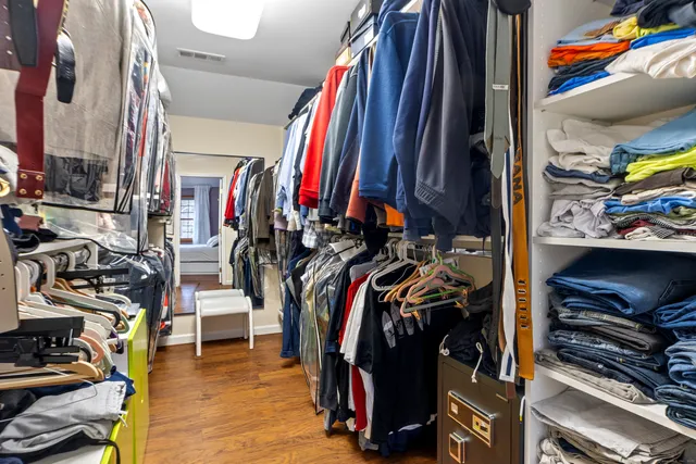 a view of walk in closet with clothes and shoes