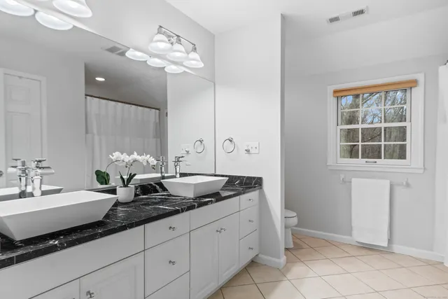 a spacious bathroom with a granite countertop sink a mirror and a vanity