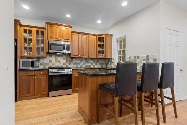 a kitchen with stainless steel appliances granite countertop a stove top oven a sink dishwasher and cabinets with wooden floor