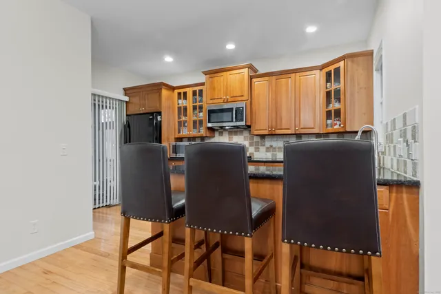 a view of kitchen with stainless steel appliances granite countertop cabinets and a refrigerator