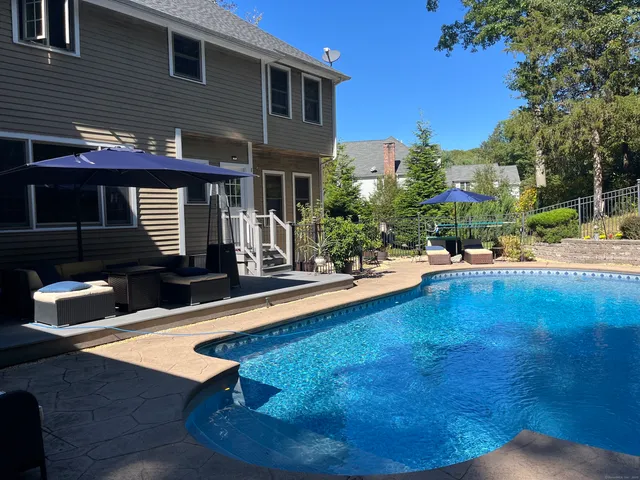 a swimming pool with outdoor seating yard and barbeque oven